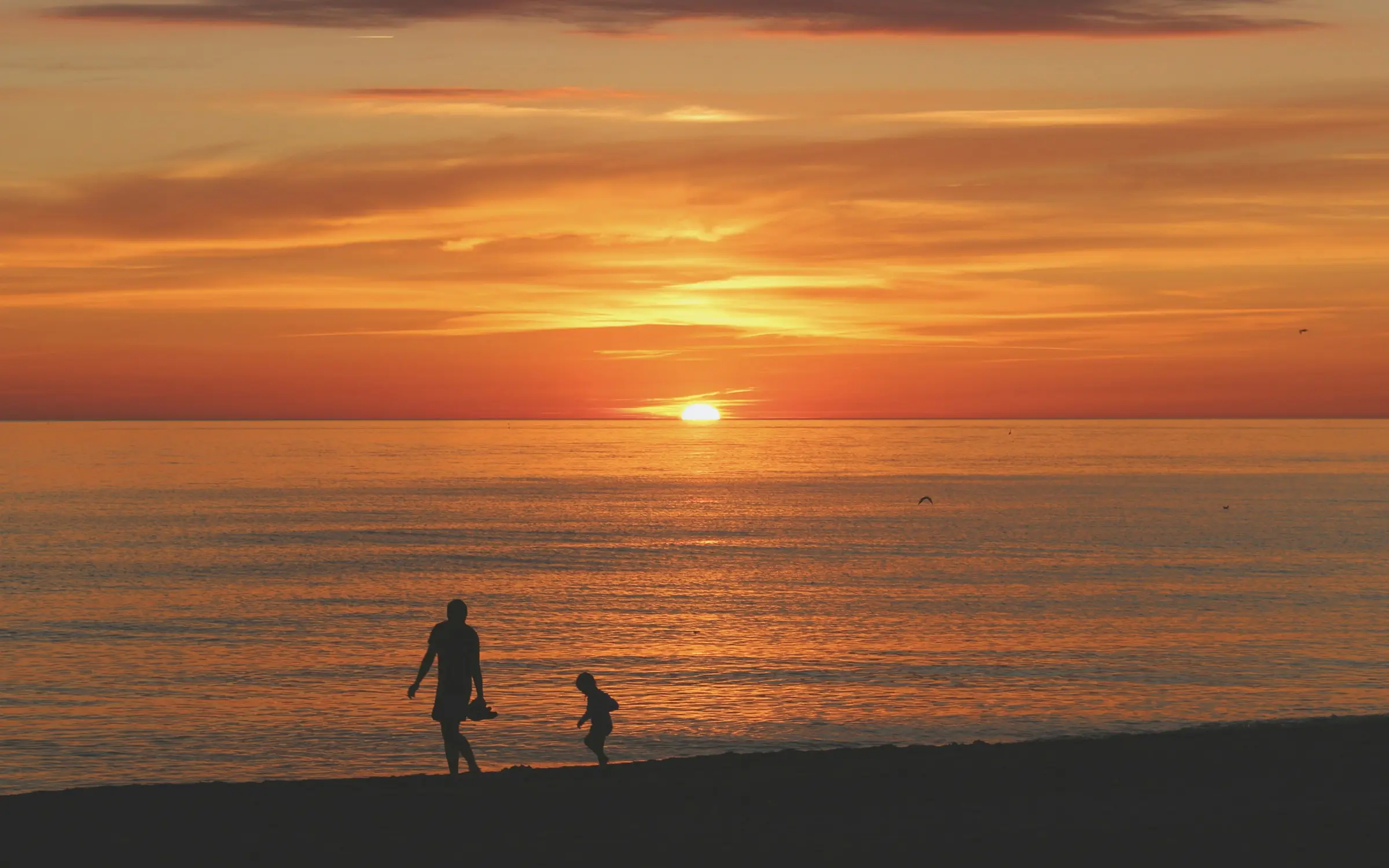 Antoine marche sur la plage au coucher du soleil, apaisé.